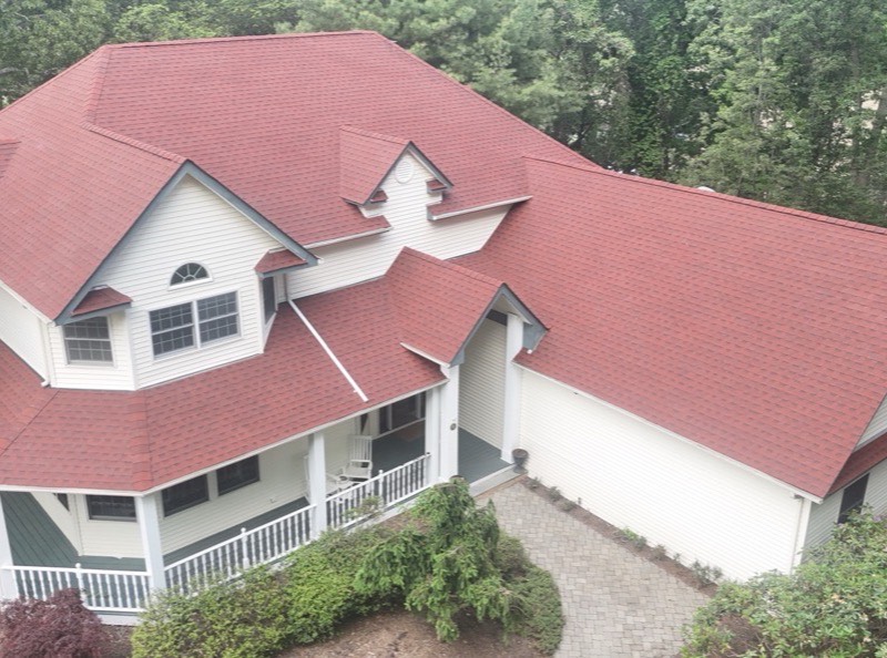 After: aerial view of the finished red architectural shingle roof across every gable, dormer and valley