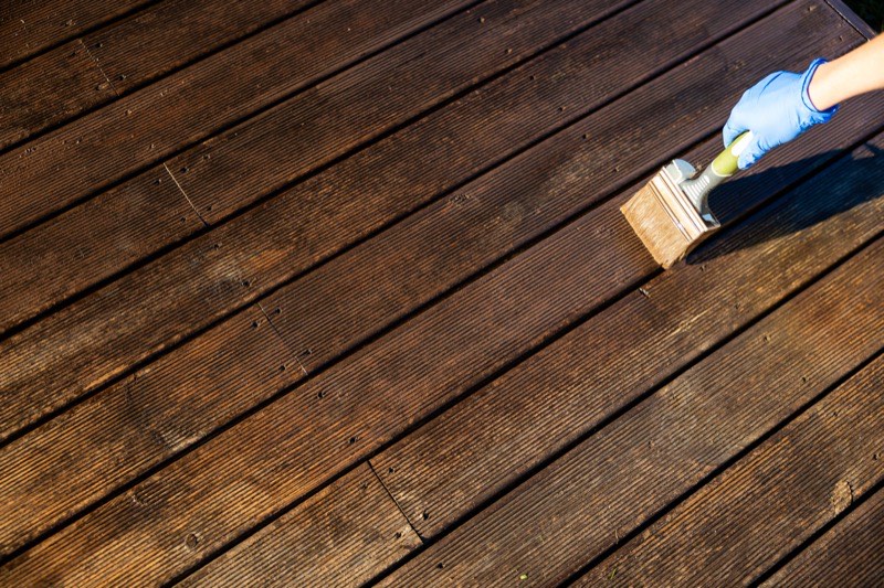 Sealer being applied to a wood deck