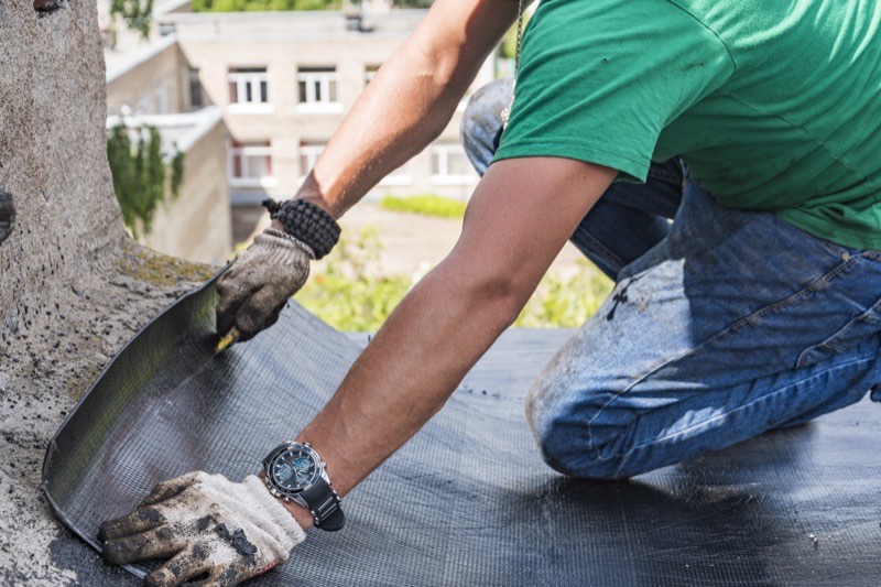 Flat membrane roof being repaired on a Long Island building